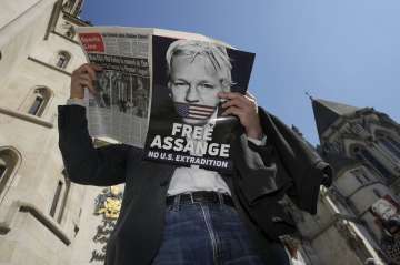 A protestor posing with the poster of "Free Julian Assange". 