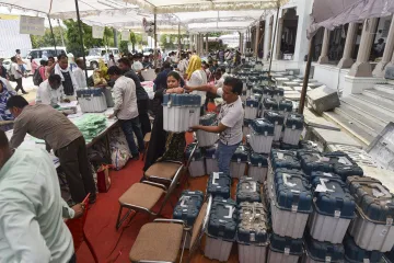 Polling officials receive the Electronic Voting Machines (EVM) and Voter Verifiable Audit Paper Trail (VVPAT) at KP Inter College on the eve of the sixth phase of Lok Sabha elections