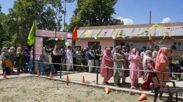People wait in queues to cast their votes during the Lok Sabha elections in Baramulla district.