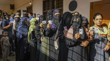 People wait in queues to cast their votes at a polling station during the 3rd phase of Lok Sabha polls, in Karnataka.