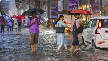 People wade through water logged street after heavy rains in Kochi.