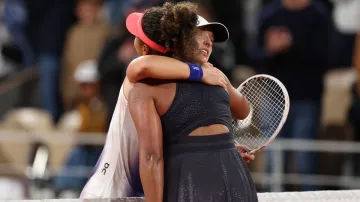 Iga Świątek embraces Naomi Osaka after a hard fought win.