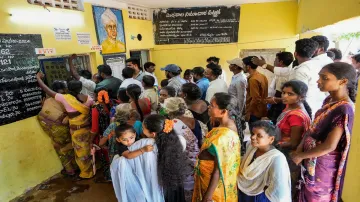 Voters stand in a queue at a polling station to cast their votes in Lok Sabha Elections 2024.