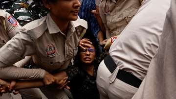 Police personnel detain a student during a protest outside Ministry of Education against the cancellation of the UGC-NET examination at New Delhi
