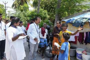 Health officials interact with locals after the recent liquor tragedy in Kallakurichi
