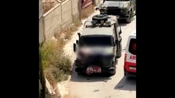 Israeli army straps Palestinian on military jeep during raid in Jenin, West Bank.
