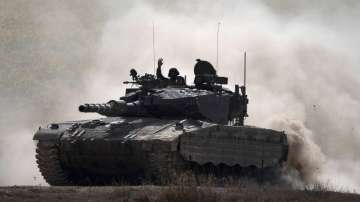 An Israeli soldier drives a tank near the Israeli-Gaza border.