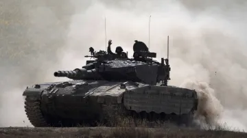 An Israeli soldier drives a tank near the Israeli-Gaza border.