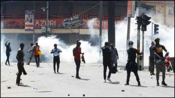 Demonstrators gesture as police use tear gas to disperse protesters in Kenya.