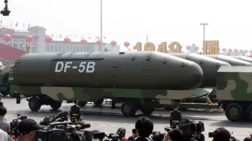 Military vehicles carrying DF-5B intercontinental ballistic missiles travel past Tiananmen Square du