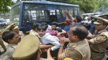Police personnel detain students during a protest over the cancellation of UGC-NET 2024 exam, outside Lucknow University
