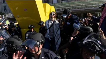 A Pro-Palestinian protestor is detained by New York Police officers outside the Brooklyn Museum.