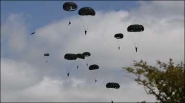 Parachutists jump from WWII-era planes into now peaceful Normandy to commemorate D-Day .