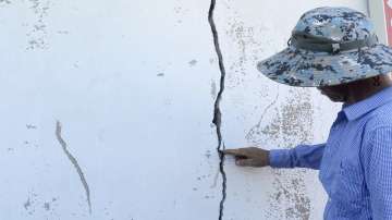 A resident points a cracked wall at a home damaged by an earthquake in Buan, South Korea.