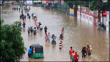 Villagers walk through a flooded road in Biyagama, Sri Lanka.