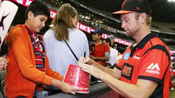 Cameron White signs an autograph.