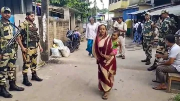 Security personnel keep vigil as voters arrive at a polling booth during repolling due to election irregularities, for Lok Sabha polls, in North 24 Parganas. (Representational image)