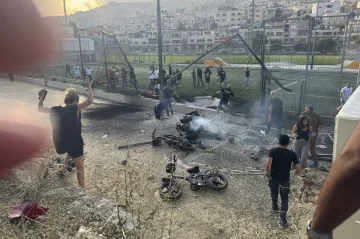 Residents rush to help injured children moments after a rocket attack hit a soccer field in the Druze town of Majdal Shams in the Israeli-controlled Golan Heights