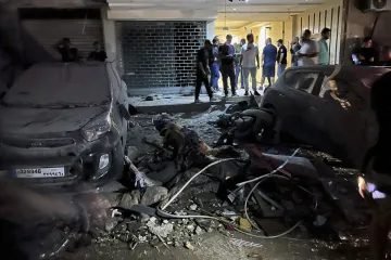 People inspect damaged cars in the southern suburbs of Beirut, Lebanon, Tuesday, July 30, 2024