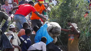 Volunteers carry a body of an unknown person retrieved, with seven others, from a dumpsite in Mukuru slums