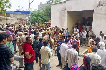 Relatives outside a hospital where victims of the Hathras stampede are admitted, in Etah