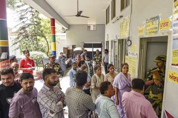 People stand in queue to cast their vote