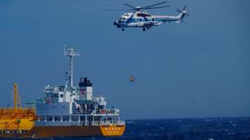 A woman is airlifted by a coast guard helicopter off Nojimazaki, Chiba prefecture, Japan.