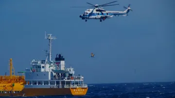 A woman is airlifted by a coast guard helicopter off Nojimazaki, Chiba prefecture, Japan.