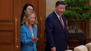 Chinese President Xi Jinping, right, walks with Italian Premier Giorgia Meloni, left, for a meeting at the Diaoyutai State Guesthouse in Beijing