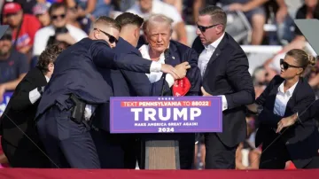 Republican presidential candidate former President Donald Trump is helped off the stage at a campaig