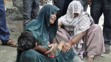  A woman is consoled as she mourns after her son died in a stampede outside a hospital in Hathras di