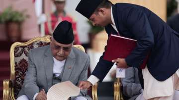 Newly appointed Prime Minister KP Sharma Oli signs a document after taking the oath of office at the