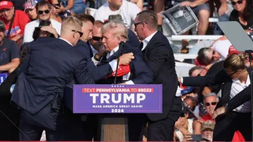 Republican presidential candidate and former Donald Trump is assisted by US Secret Service personnel