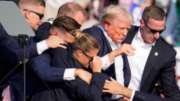 Republican presidential candidate former President Donald Trump is helped off the stage by U.S. Secr