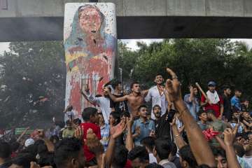 A mob vandalising the poster of former PM Sheikh Hasina in Dhaka