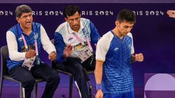 Prakash Padukone and U. Vimal Kumar cheering Lakshya Sen on during his bronze medal match against Lee Zii Jia