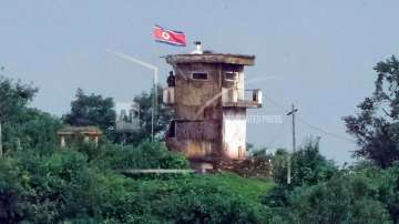 A North Korean soldier stands at the North's military guard post as a North Korean flag flutters in 