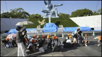 Visitors to the Peace Park crouch as an earthquake alert was issued in Nagasaki, western Japan.