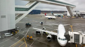 Planes taxi under the aerial passenger walkway at Seattle-Tacoma International Airport