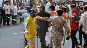 Protesters escort two suspected Awami League supporters after beating them in front of Bangabandhu S