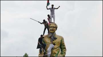 People climb the statue of Sheikh Mujibur Rahman at the Bijoy Sarani area after Sheikh Hasina's ouster.