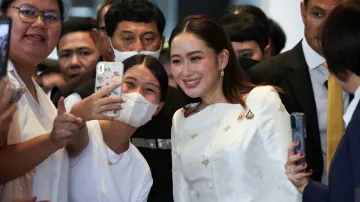 Thailand's Prime Minister Paetongtarn Shinawatra poses for photographs with supporters after a press