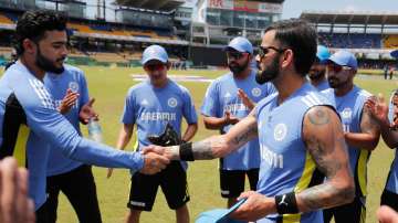 Virat Kohli presents Riyan Parag with his ODI debut cap.