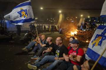 People block a road as they protest calling for a deal for immediate release of hostages held in the