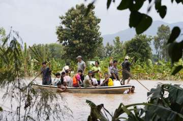 Local residents carrying food on their cart wade through a flooded road in Naypyitaw, Myanmar