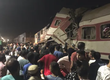 People surround two passenger trains which collided in Egypt's Nile Delta city of Zagazig, the provi