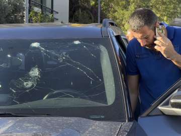 Police officers inspect a car inside of which a hand-held pager exploded, Beirut