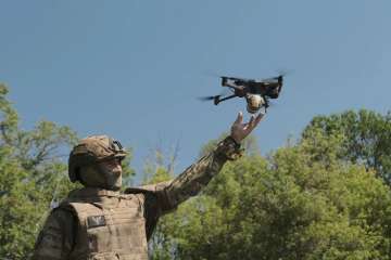 A military personnel posing with drone