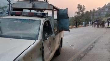 A police vehicle lies damaged after it was caught in an explosion on Malam Jabba Road