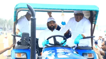 Maharashtra CM Eknath Shinde drives a tractor during a mega beach cleaning campaign at Juhu Beach in Mumbai.